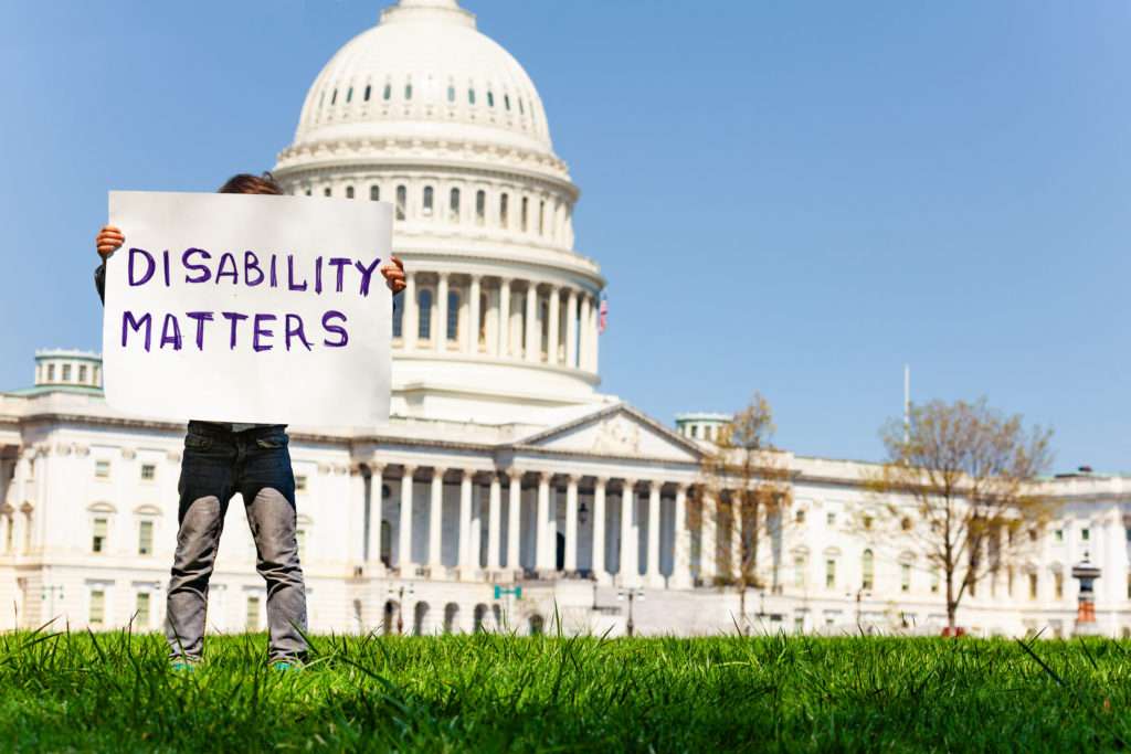 Boy holding Disability Matters sign